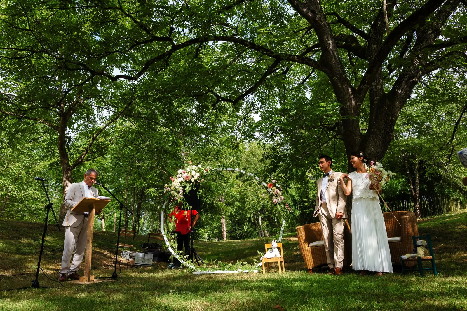 La cérémonie laïque en extérieur, devant l'arche fleurie, sous les grands arbres